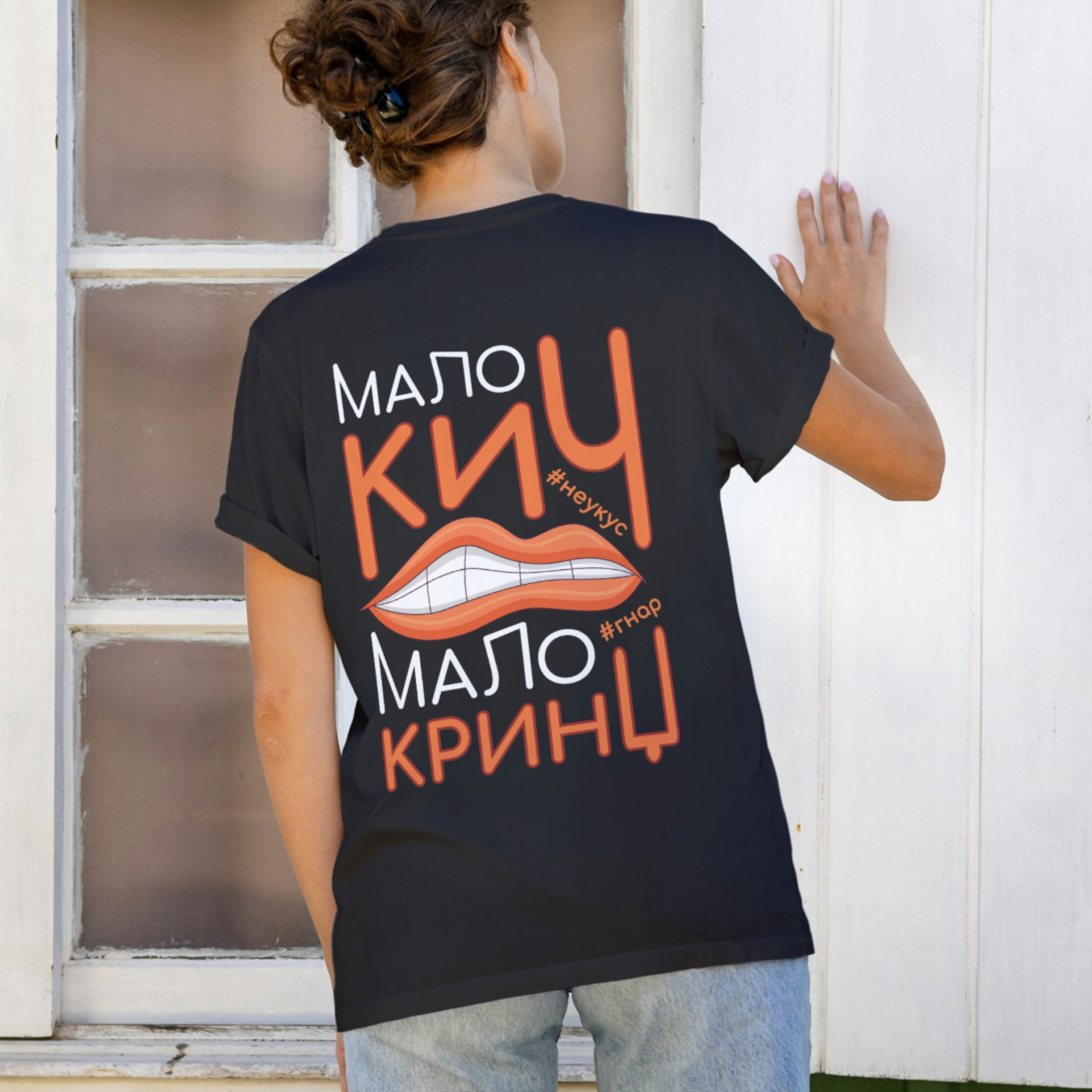 Девојка у црној мајици са дизајном "Мало кич мало кринџ" на леђима