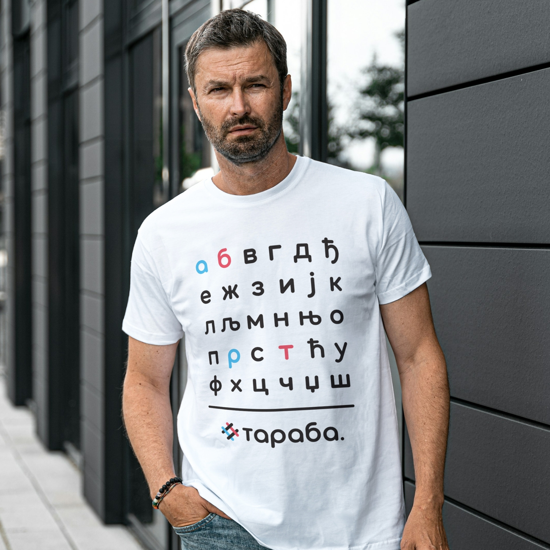 Мушкарац у белој мајици са дизајном азбуке и Тараба логомарком