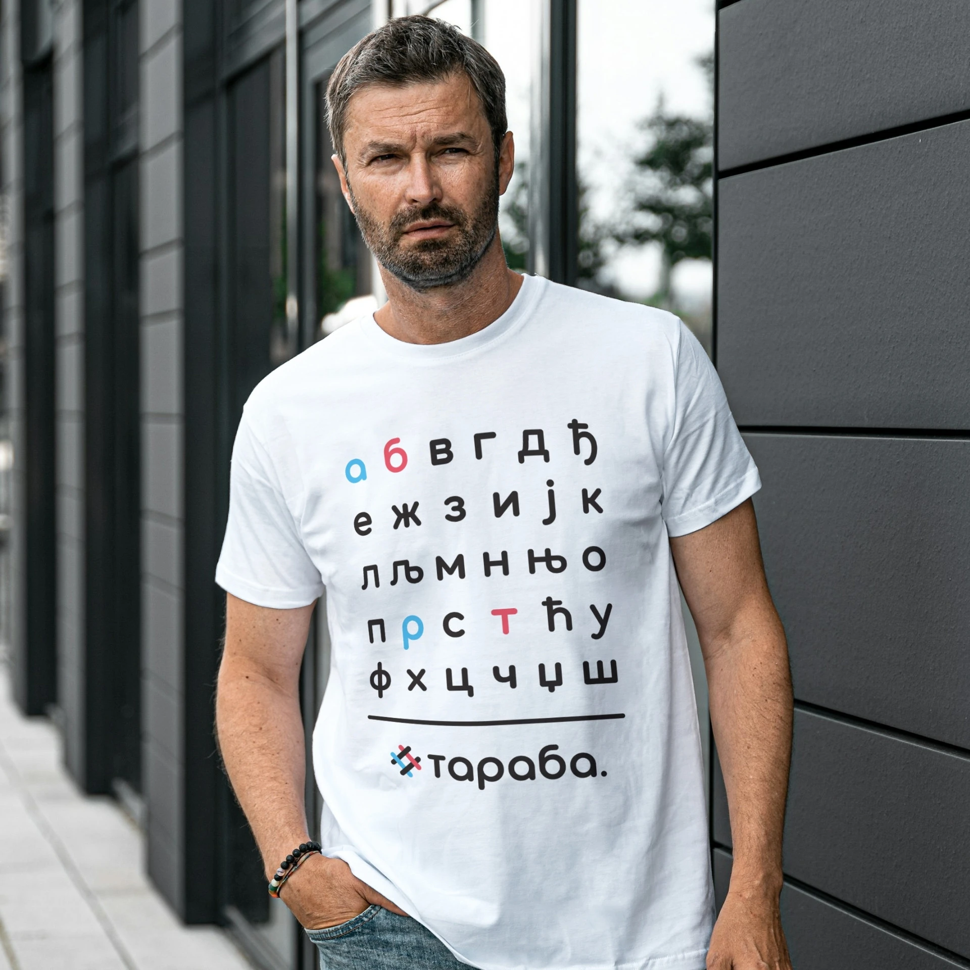 Мушкарац у белој мајици са дизајном азбуке и Тараба логомарком